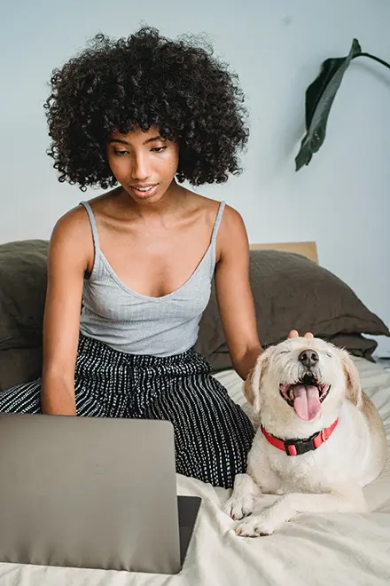Person on a computer, with a dog